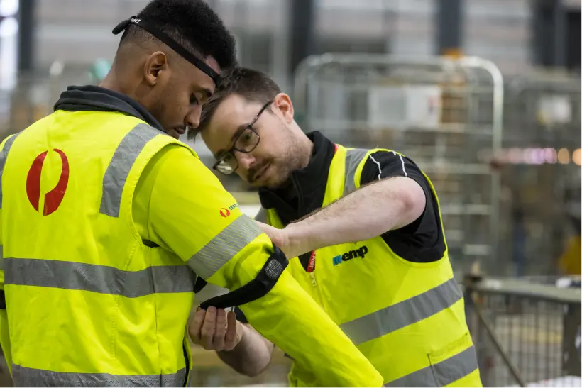 Exercise physiologist placing Bluetooth wearable sensors on a warehouse worker.