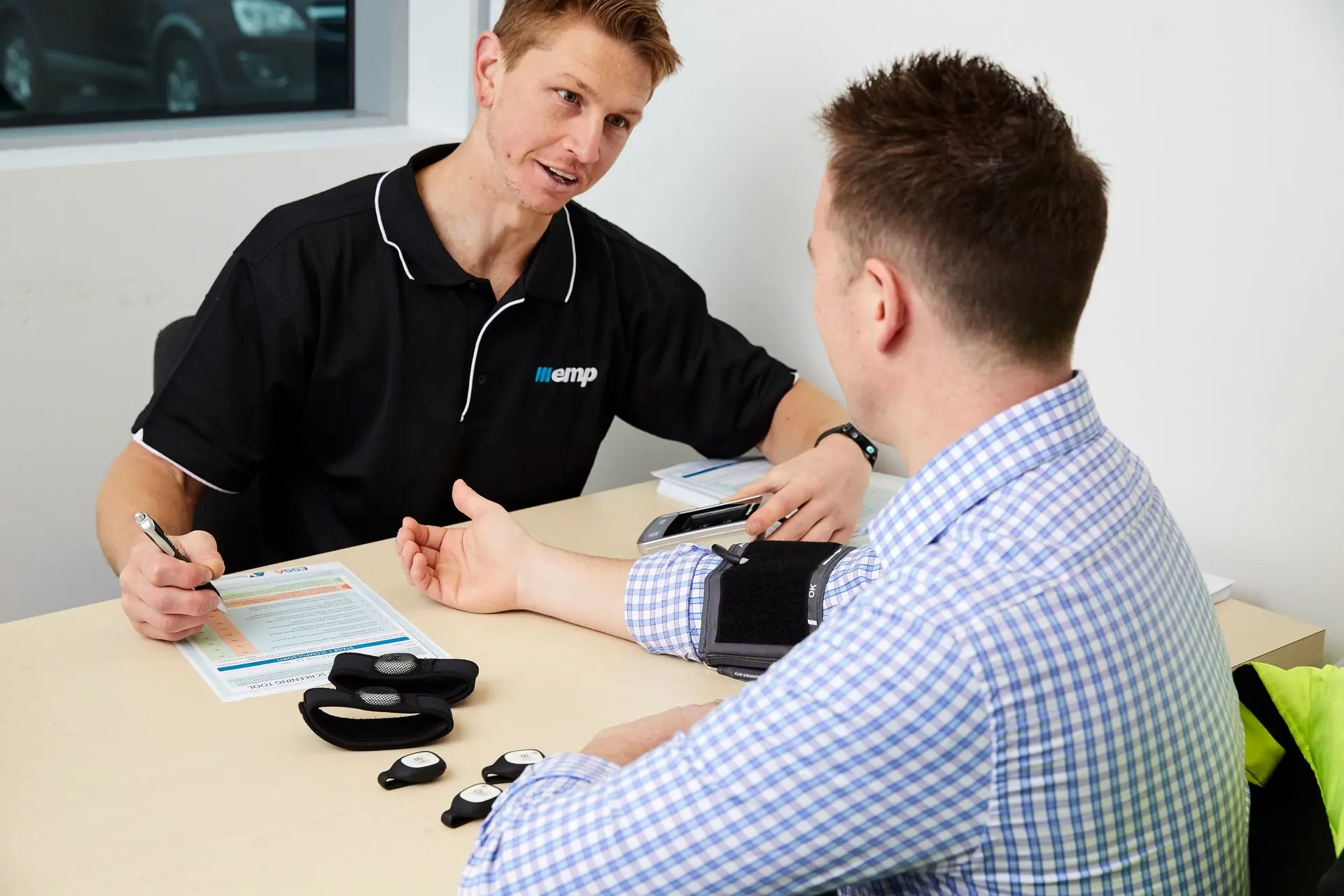 An EMP Onsite clinician measuring a participant's blood pressure during a health screening.
