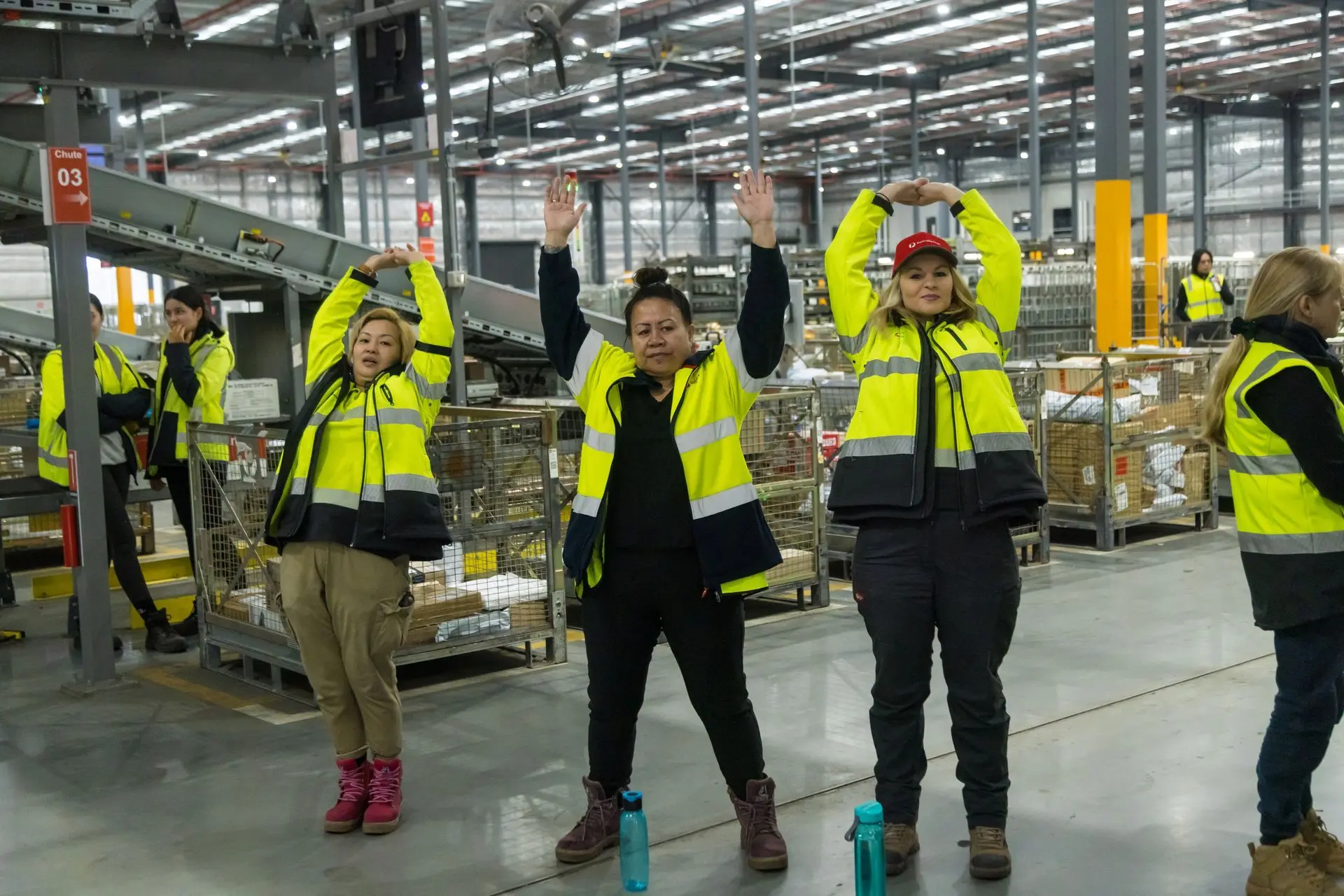 Warehouse workers performing a stretching routine